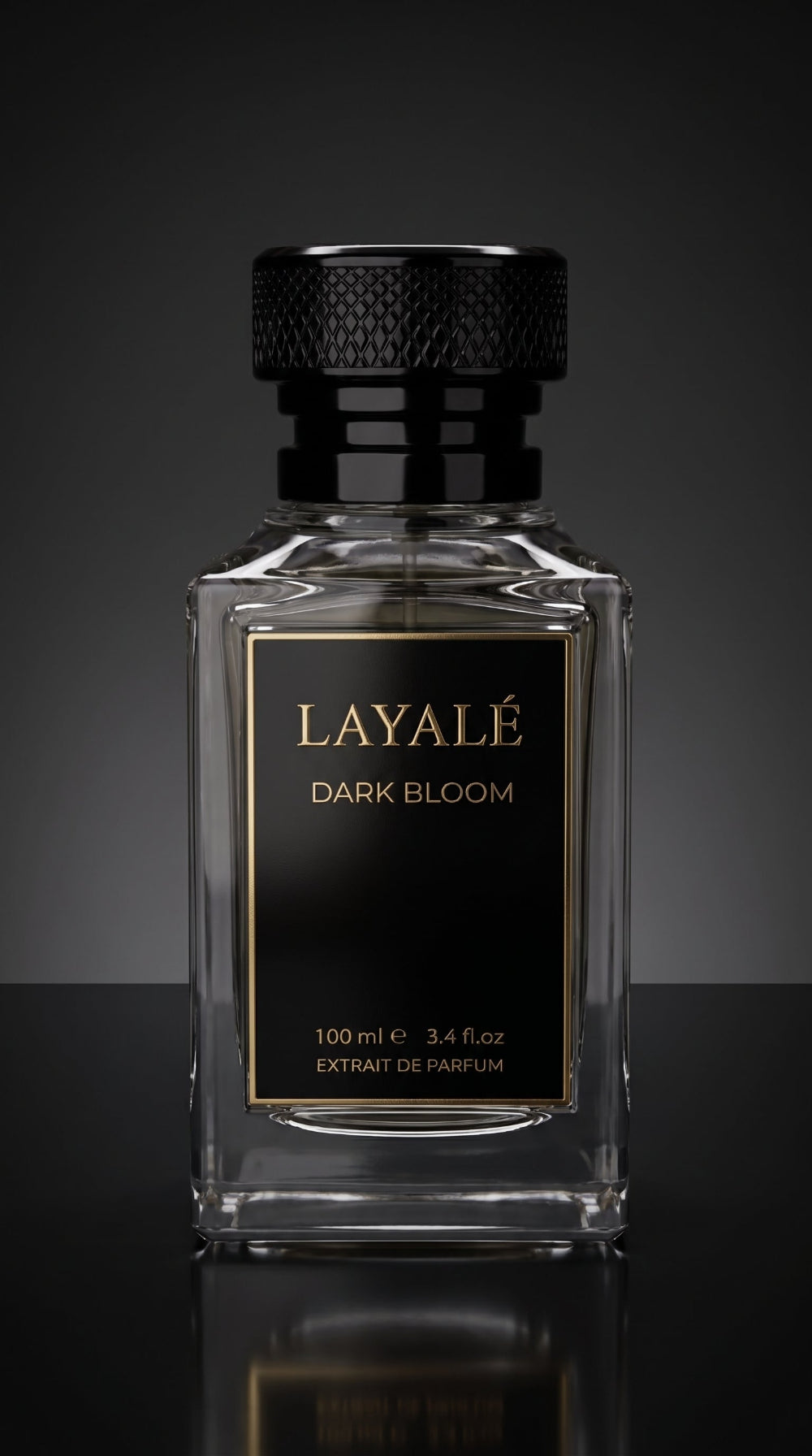 A clear rectangular glass perfume bottle with a black cap and a black front label featuring gold lettering that reads 'LAYALÉ DARK BLOOM'. The bottle is centered against a dark gray gradient background with a reflective surface below.
